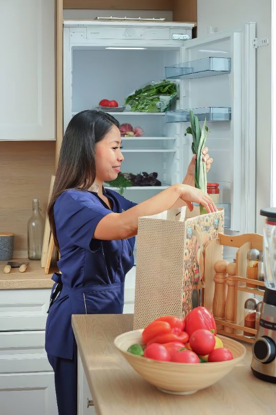 Optimistic nanny preparing vegetables to cook